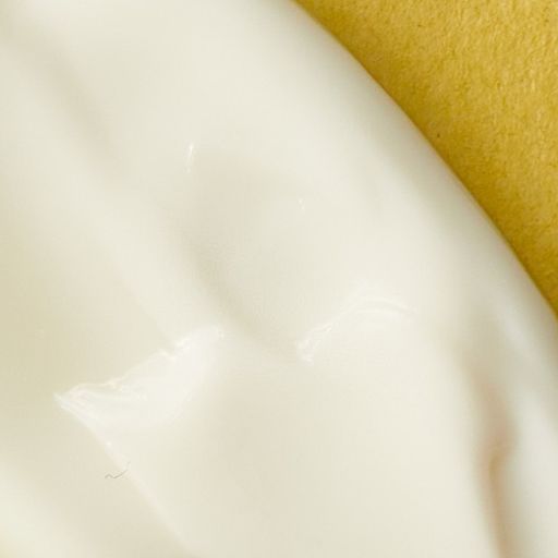 Creamy lotion texture on yellow background