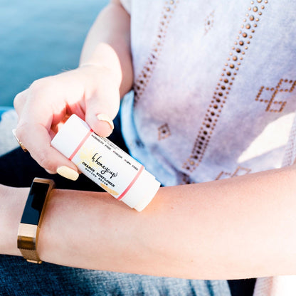 Close up of woman applying H. Honeycup lotion stick