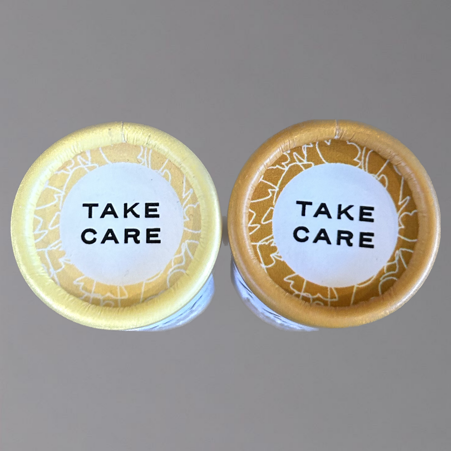 Lotion Stick and Lip Balm tops showing Take Care words