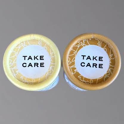 Lotion Stick and Lip Balm tops showing Take Care words