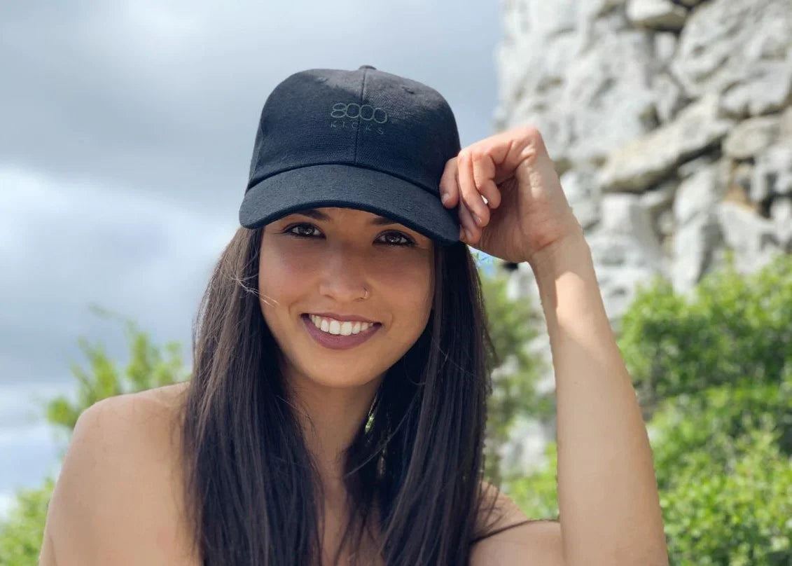 A smiling woman wearing a black hemp hat by 8000 Kicks.