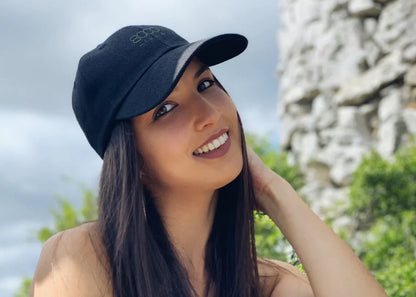 A young smiling woman wearing a black 8000 Kicks hemp hat.